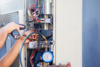 Male Technician Hands Using a Screwdriver Fixing Air Conditioner — Air Conditioning Professionals in Forster, NSW Male Technician Hands Using a Screwdriver Fixing Air Conditioner — Air Conditioning Professionals in Forster, NSW